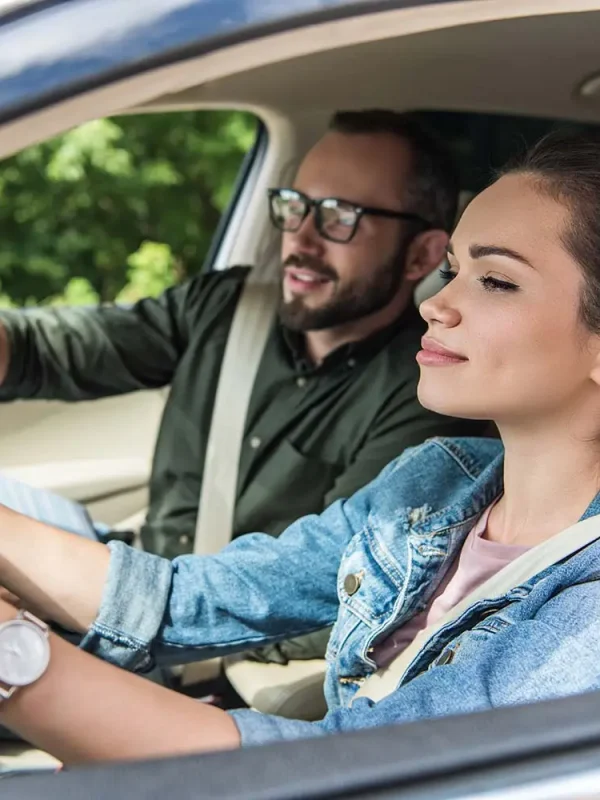 cheerful-student-and-teacher-in-car-at-driving-tes-8WUZ9MG.jpg